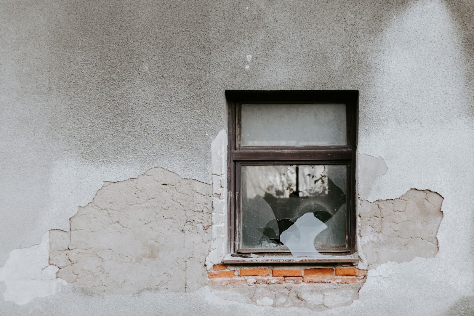 fenêtre d'une maison et mur abîmé