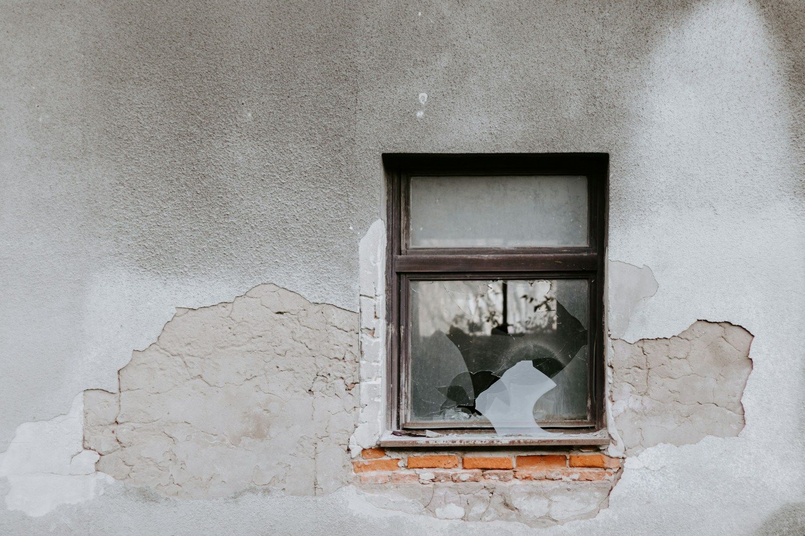 fenêtre d'une maison et mur abîmé