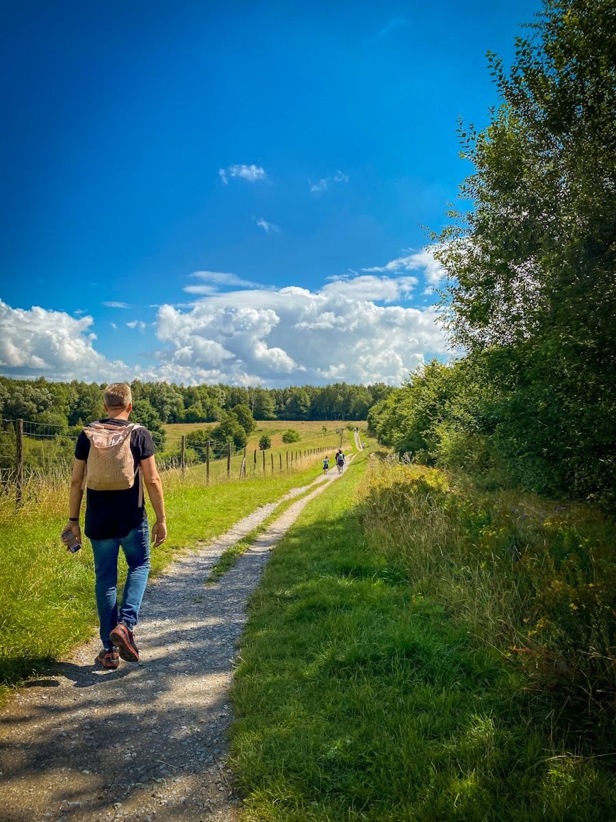 personne qui randonne sur un chemin de campagne