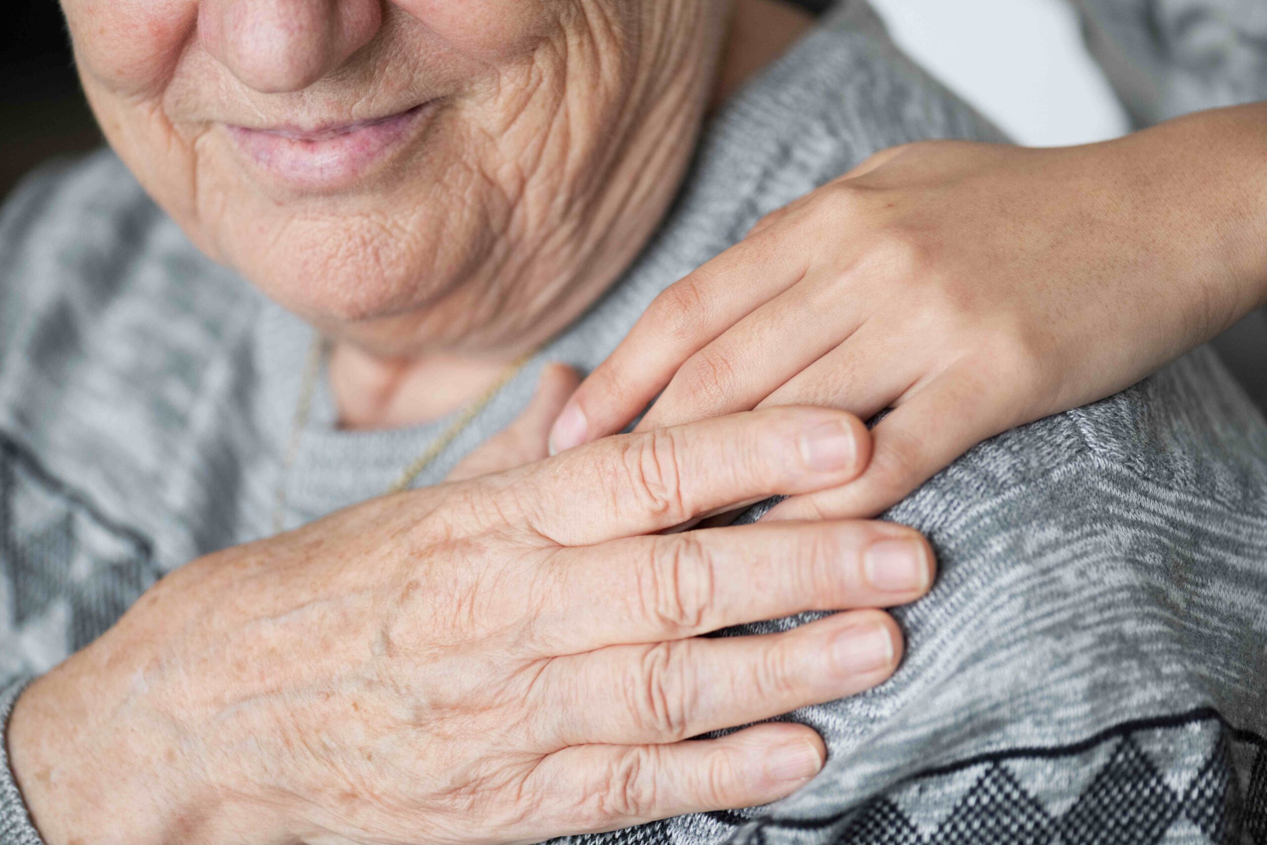Visage d'un senior en gros plan avec une main sur l'épaule