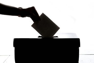 personne insérant son bulletin de vote dans une urne électorale