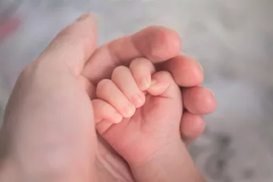 Main d'un bébé dans la main d'un adulte